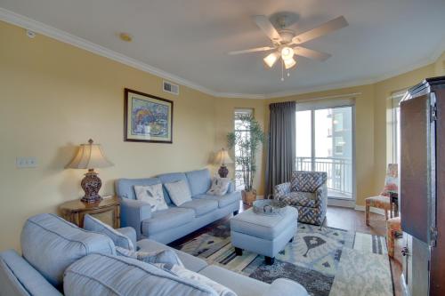 a living room with blue couches and a ceiling fan at Gulfport Condo with Views Walk to Beach in Gulfport