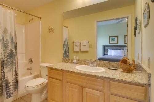 a bathroom with a sink and a toilet and a bed at 6th-Floor Gulfport Condo with Views Walk to Beach in Gulfport
