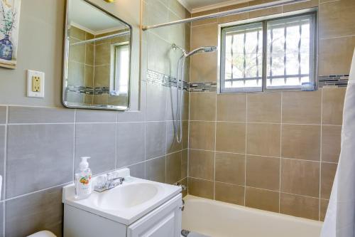 a bathroom with a sink and a shower and a mirror at Cozy Memphis Vacation Rental Near Beale Street! in Memphis