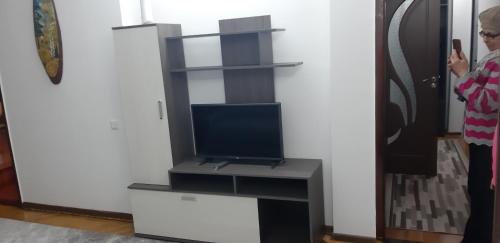 a woman standing in a living room with a tv at Сдаётся квартира , посуточно в центре города in Edineţ
