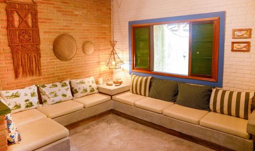 un salon avec un canapé et une fenêtre dans l'établissement Otima casa c Wi Fi 8 min da praia Barequecaba SP, à São Sebastião