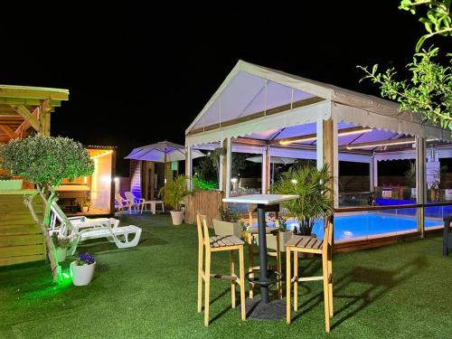 - une terrasse avec une tente et une piscine la nuit dans l'établissement צימר היעד, à Dāliyat el Karmil