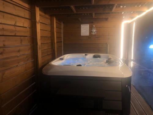 eine Badewanne in einem Zimmer mit einer Holzwand in der Unterkunft צימר היעד in Dāliyat el Karmil