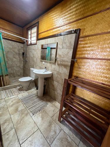 La salle de bains est pourvue d'un lavabo, de toilettes et d'une douche. dans l'établissement HEIRAI TAHITI EXPERIENCE, à Vairao