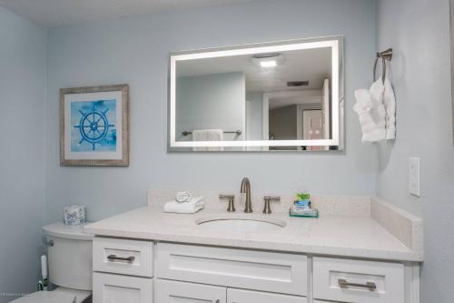 y baño con lavabo y espejo. en Our House At The Beach, East Tower, 5th Fl en Siesta Key