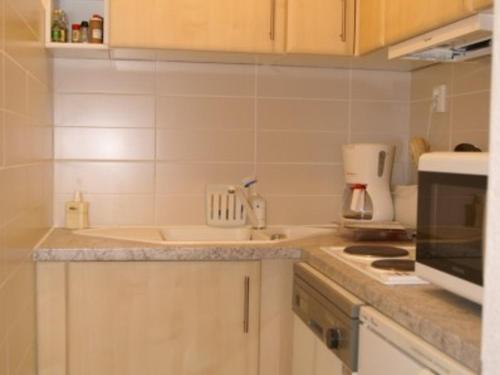 une cuisine avec un évier et une cuisinière dans l'établissement 3 pièces au pied des pistes avec balcon et casier à skis - FR-1-557-7, à Les Adrets