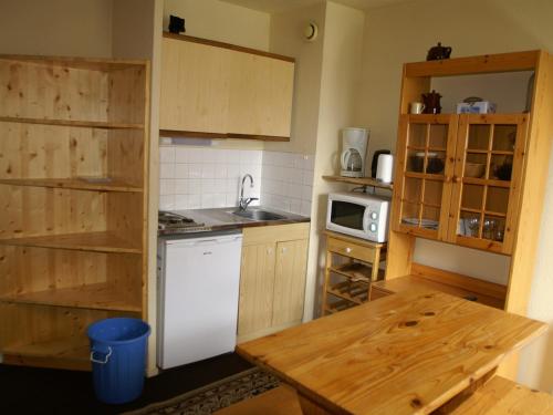 Elle comprend une petite cuisine équipée d'un réfrigérateur blanc et d'une table. dans l'établissement Studio cabine au pied des pistes avec balcon et casier à skis - FR-1-557-13, à Les Adrets
