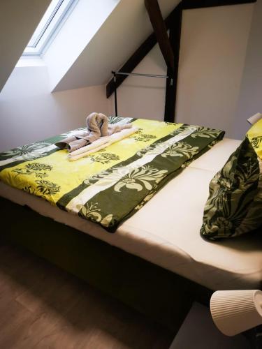 uma cama com um cobertor verde e branco em ubytování U NIKY em Hodonín