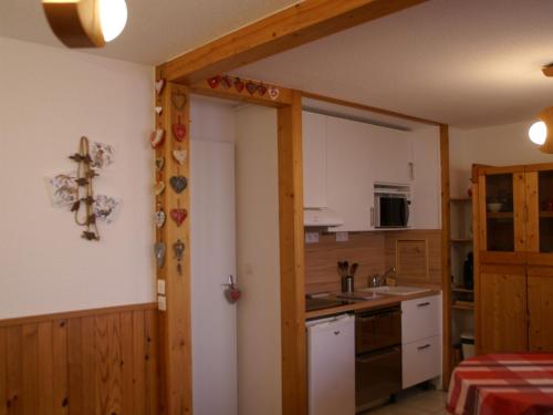une cuisine avec une porte menant à une chambre dans l'établissement Pied des pistes, Appt confort, 4 pers, balcon - FR-1-557-53, à Les Adrets