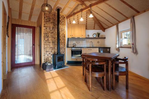 a kitchen with a wooden table and a stove at Refúgio House Natura Moinho de Água - Eco House in Guimarães