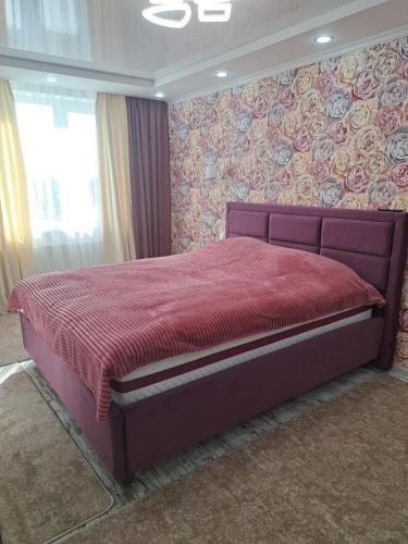 a bedroom with a bed with a red comforter at Сдаётся квартира почасовой, посуточно in Edineţ