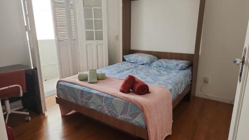 a bedroom with a bed with two pillows on it at Casa Ipê Baobá in São Paulo