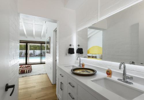 a white kitchen with a sink and a mirror at The Kasbah in Palm Springs