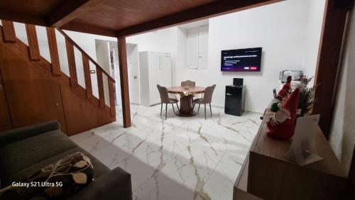 uma sala de estar com uma mesa e uma televisão em San Ciro's Suite em Portici