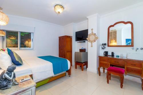 a bedroom with a bed and a desk and a sink at Voilá Signature Casa Isabel in Cartagena de Indias
