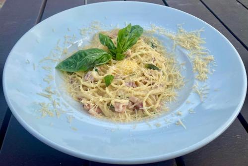 a plate of pasta with meat and basil on a table at Райский Дворик in Pogreby