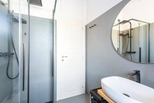 La salle de bains est pourvue d'un lavabo et d'un miroir. dans l'établissement Appartamento Milano Infinite Dreams 1 min MM1, à Milan