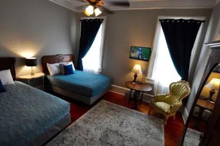 a bedroom with a bed and a chair and window at The Dragonfly Guest House in New Orleans