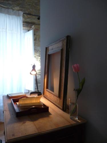 a mirror and a vase with a rose on a table at Quinta da Eira Velha in Aldeia do Mato
