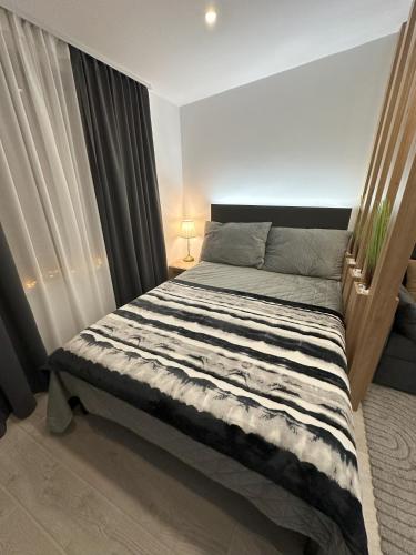 a bedroom with a large bed with curtains at Dux Apartmani - Milmari, Kopaonik in Cajetina
