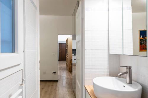 a white bathroom with a sink and a mirror at Le Ninfee in Bologna