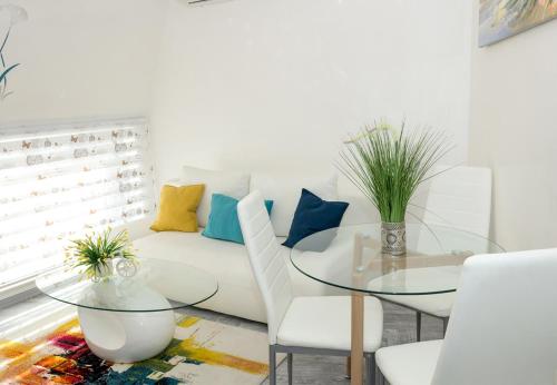 sala de estar con sofá blanco y mesa de cristal en Cozy Central Apartment, en Varna