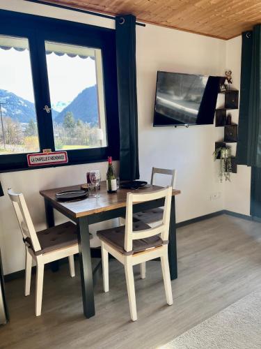 une salle à manger avec une table et des chaises et une fenêtre dans l'établissement Appartement neuf à 400 m des remontées avec Sauna, à La Chapelle-dʼAbondance