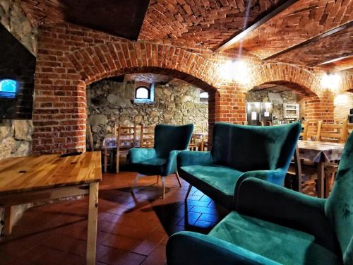 a room with chairs and a table and a brick wall at Gospodarstwo nad jeziorem in Załom