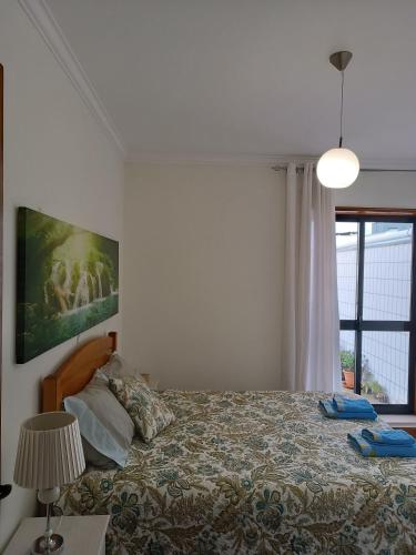 a bedroom with a bed and a large window at Apartamento Solzende in Esposende