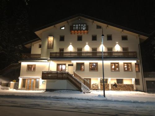 a large white building in the snow at night at Hotel I Pionieri in Abetone