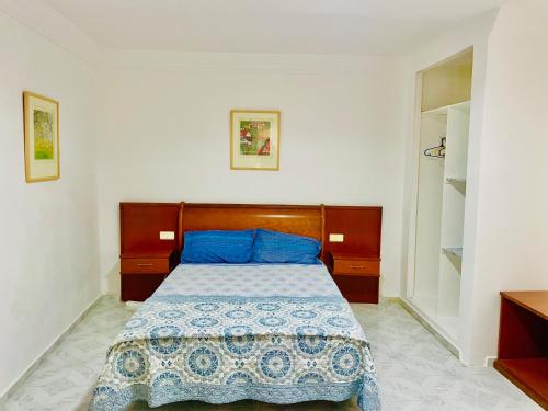 a bedroom with a bed with blue pillows at Nouadhibou Guest House in Nouadhibou