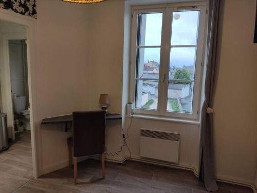 a room with a desk and a large window at Le 5, Wifi, Parking, Centre in Châteauroux