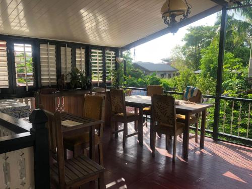 a dining room with tables and chairs on a deck at Pied a Terre in Paramaribo