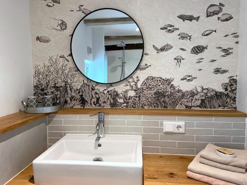 a bathroom with a white sink and a mirror at Hafenhaus No. 14 in Husum