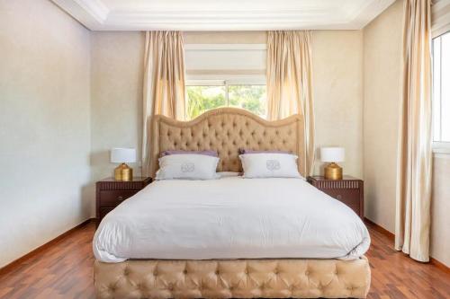 een groot bed in een slaapkamer met een groot raam bij Haddad's for families in Tanger