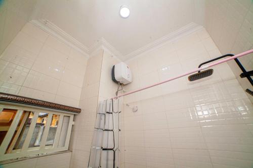 a shower in a bathroom with a phone on the wall at Schemes Hotel And Apartment in Port Harcourt