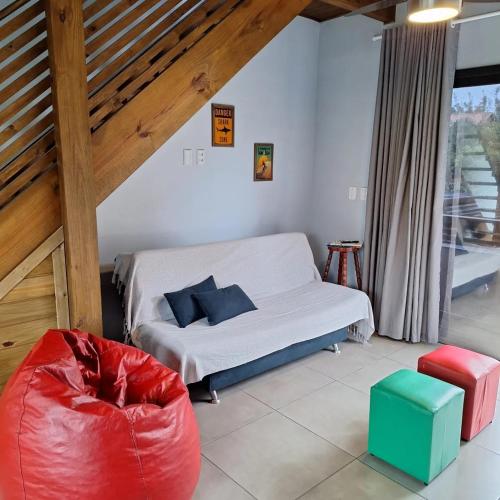 a bedroom with a bed and a red ottoman in a room at Local da Lagoa Chalés e Lofts in Imbituba