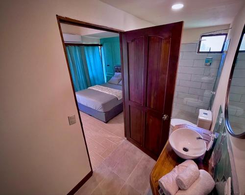 a bathroom with a sink and a bed and a mirror at Oasis by Franklin Hotel Boutique in Fortuna