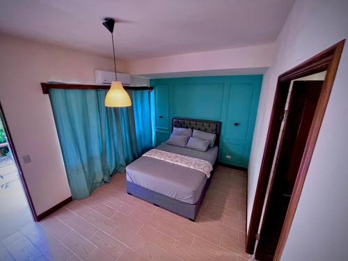 a bedroom with a bed in a room with blue walls at Oasis by Franklin Hotel Boutique in Fortuna