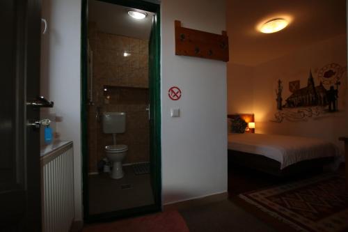 a bedroom with a bed and a bathroom with a toilet at B&B Duo Caffe Baneasa in Bucharest