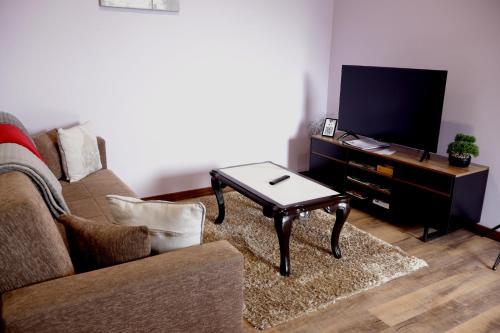 a living room with a couch and a coffee table at Village Center Two Bedroom Apartment in Porto Moniz