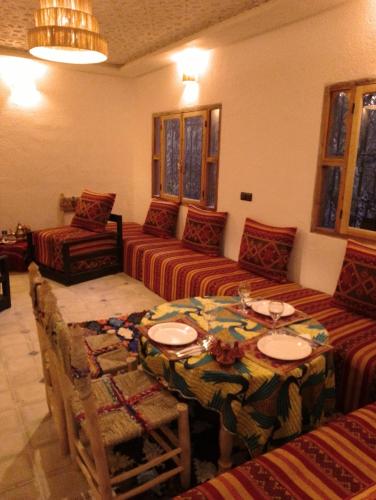 a living room with a table and a couch at RIAD IDAR ouirgane in Ouirgane