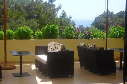 a balcony with two chairs and a table and a window at Miraluna Aparthotel in Lefkos Karpathou