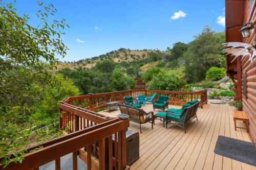 a wooden deck with chairs and a table on it at SEQUOIA LOOKOUT LODGE in Three Rivers