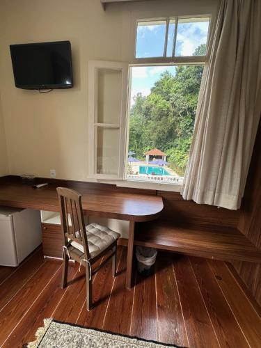 a desk with a window and a chair in a room at Pousada Princesa Isabel - Visconde in Petrópolis