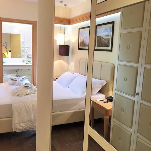 a bedroom with a bed and a mirror at Erbavoglio Hotel in Rimini