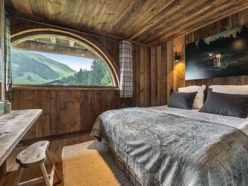 Un dormitorio con una cama grande y una ventana. en Chalet de Luxe à Val d'Isère avec Jacuzzi et Hammam - FR-1-567-8, en Val dʼIsère