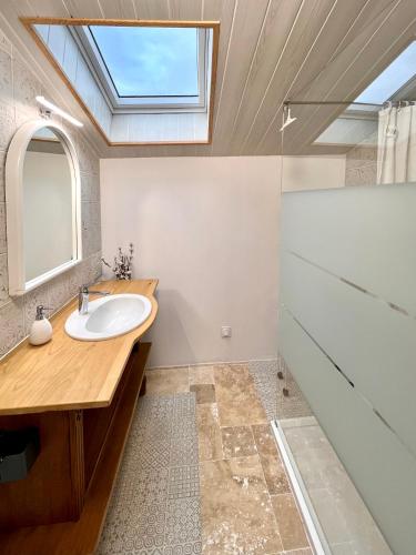 La salle de bains est pourvue d'un lavabo et d'une lucarne. dans l'établissement Ferme Gite Le Cœur des Petits Chênes, à Saint-Pierre-de-Côle