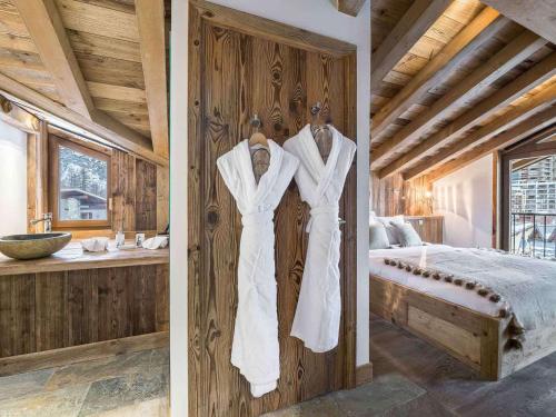 2 robes de mariage blanches suspendues sur un mur dans une chambre dans l'établissement Luxueux appartement 4 chambres avec hammam, proche centre et pistes de Val d'Isère - FR-1-567-42, à Val dʼIsère