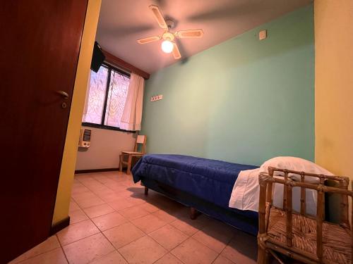 1 dormitorio con 1 cama y ventilador de techo en Hotel cuesta del viento II en San Juan
